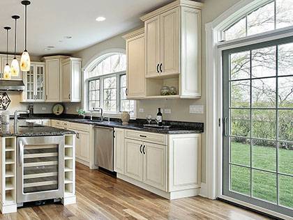 Modern spacious kitchen with cream cabinetry and large windows