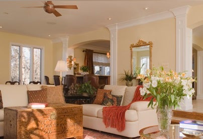 A cozy living room with beige sofas, a wooden coffee table, and warm decor.