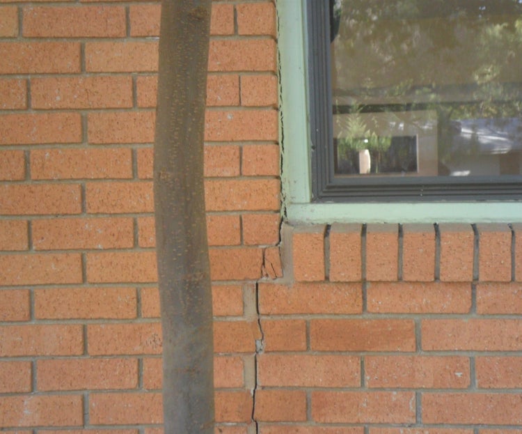 A house with visible foundation damage, such as wall cracks