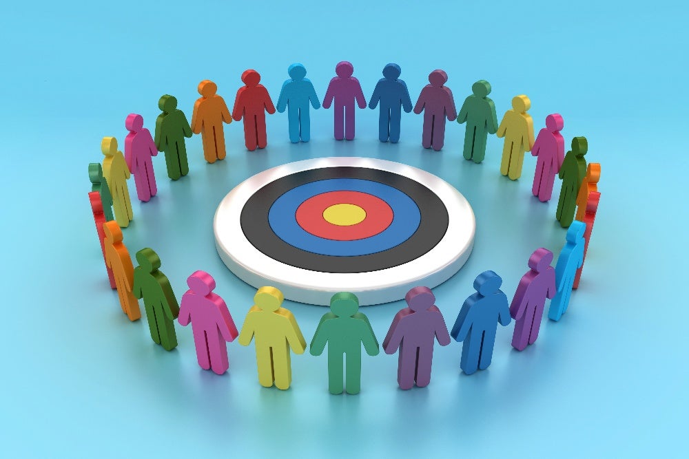 Colorful figures encircle target symbolizing diverse audience groups and target audience research