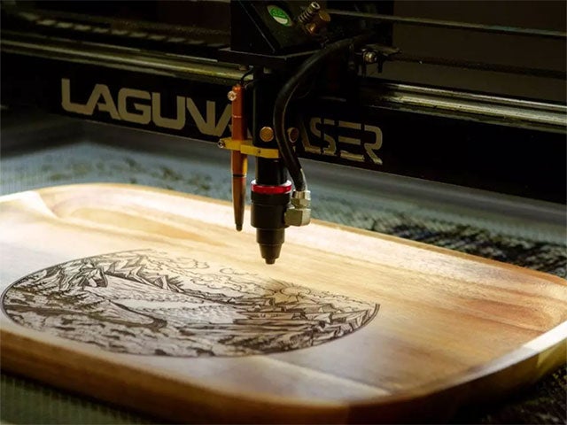 Laser engraving a detailed design on a wooden board