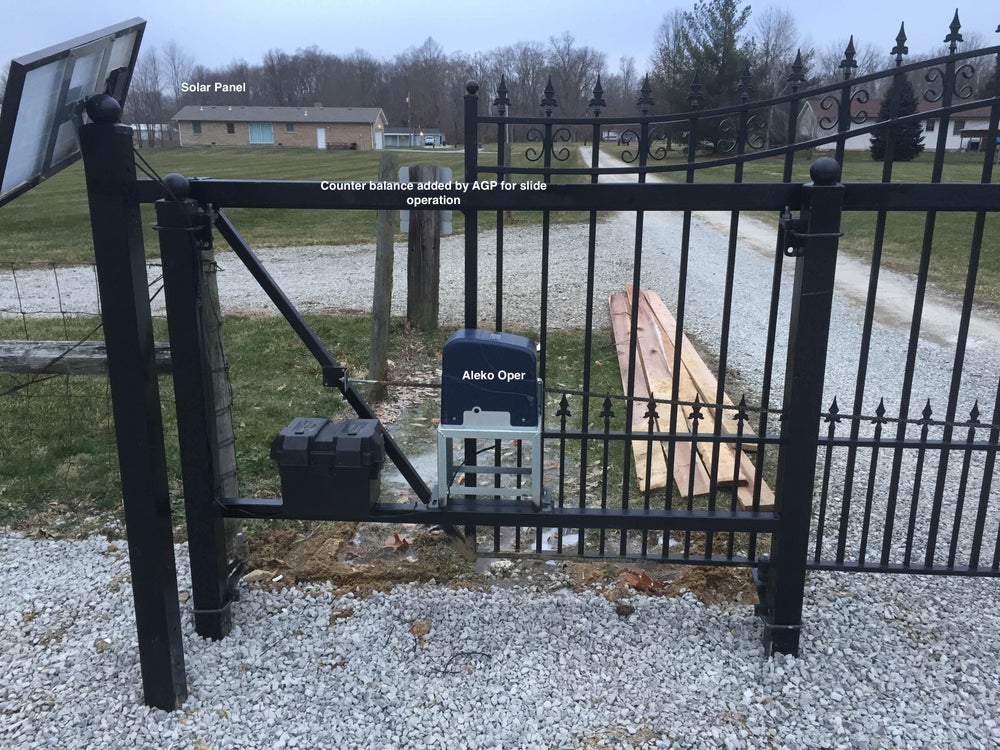 A black metal automatic sliding gate with solar-powered security features.