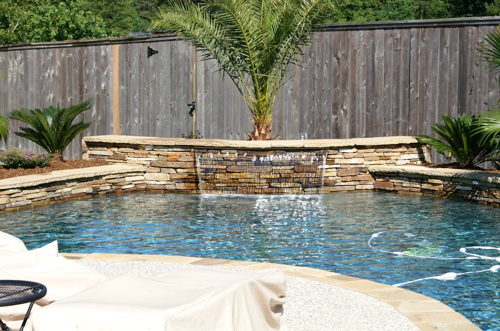 A beautiful, well-designed swimming pool in a backyard setting, showcasing the work of a top-rated pool contractor in Pearland, TX