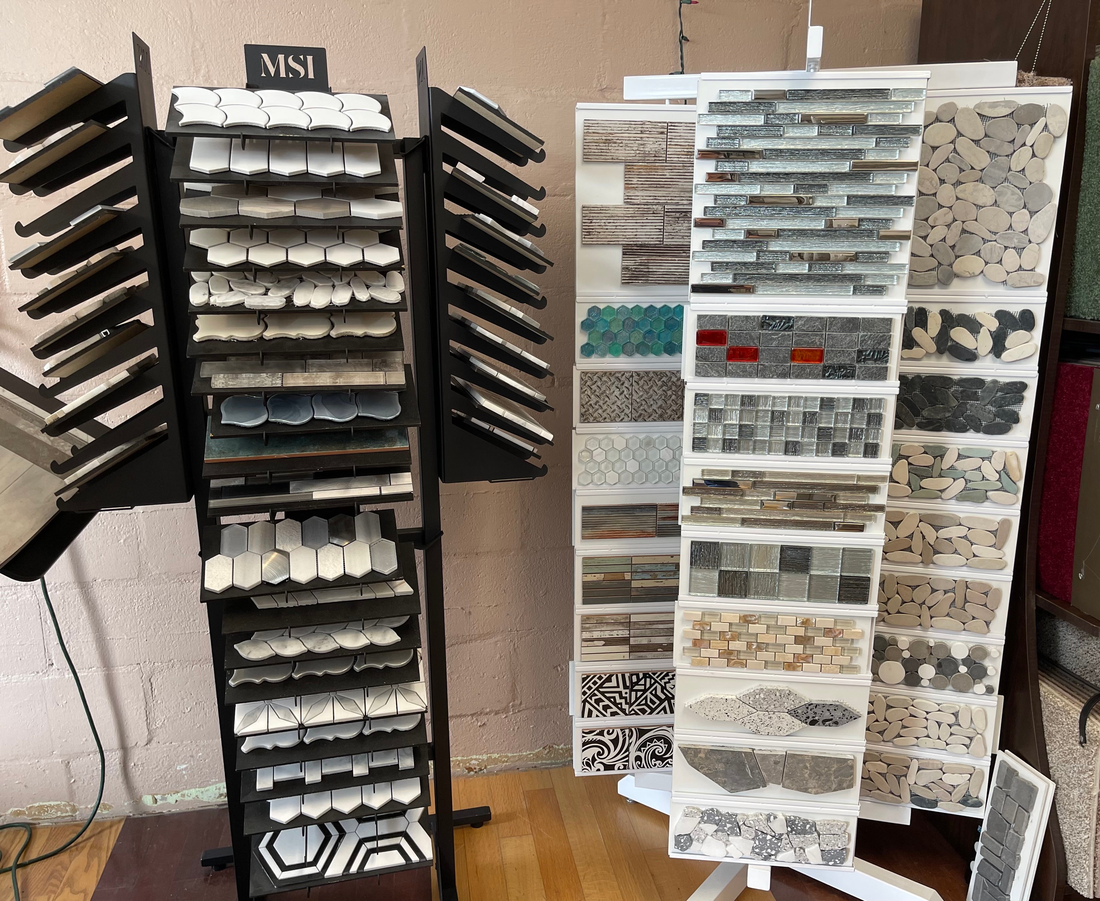 Tile display racks featuring various mosaic and patterned tile samples in diverse colors and designs