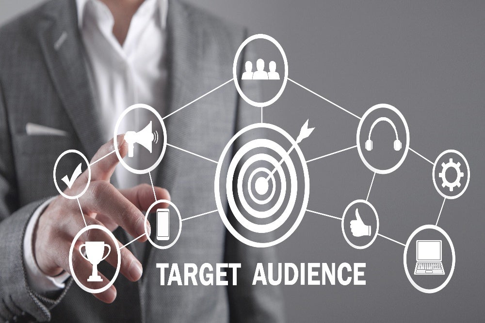 Business professional highlighting aspects of target audience research with digital marketing icons.