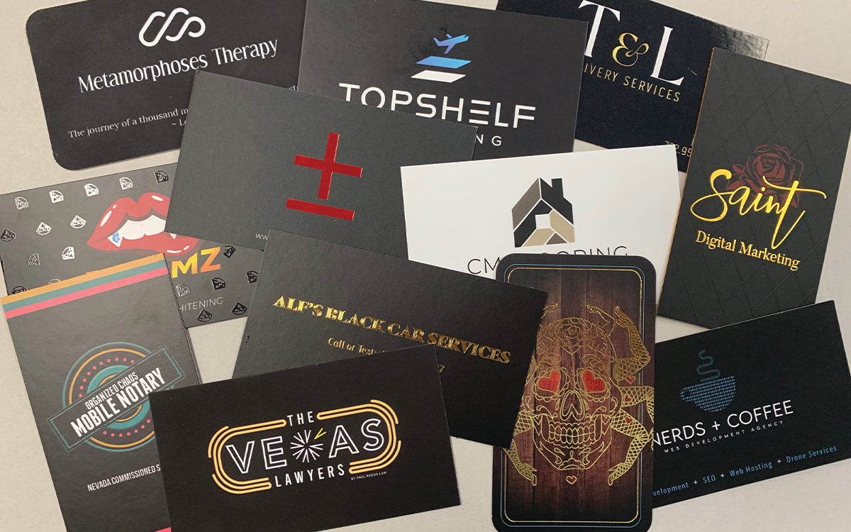 A variety of printed business cards showcasing different paper types and finishes.