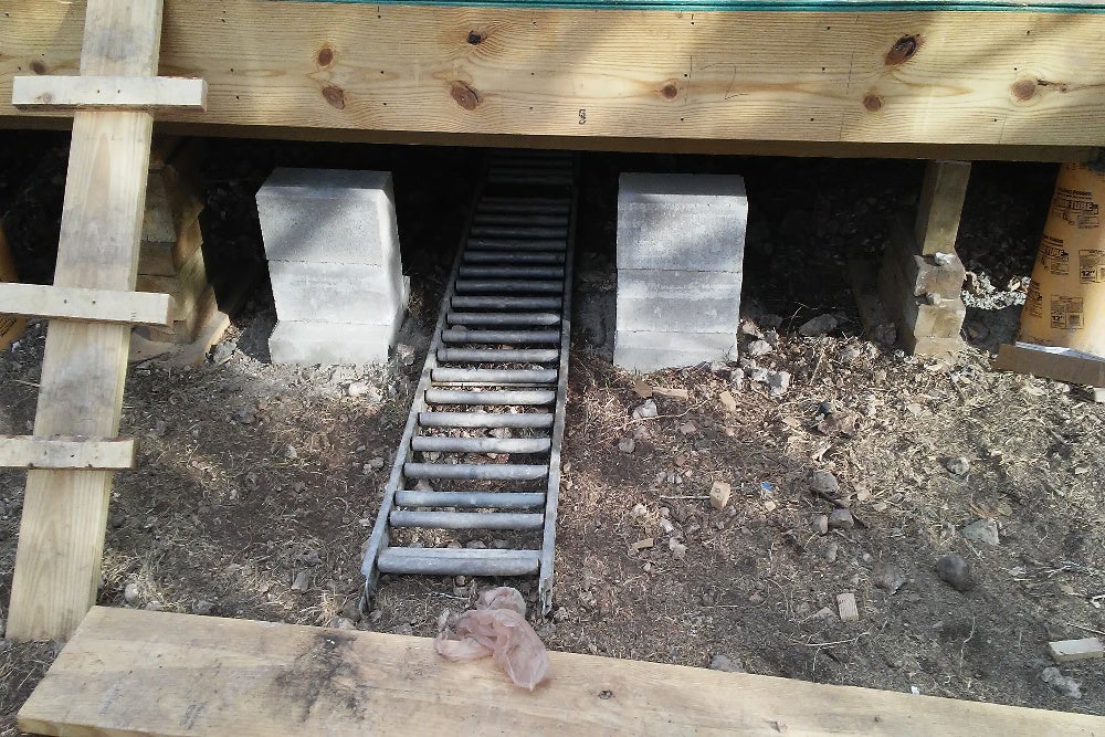 House foundation repair with temporary wooden supports and concrete blocks