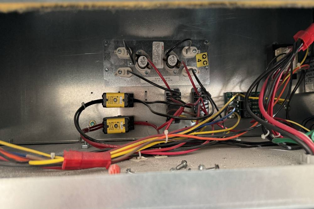 Internal components of an HVAC system showing fuses, wiring, and electrical connections.