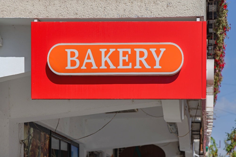 Red and orange bakery sign on building exterior