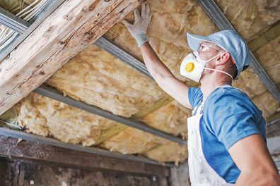 A professional insulation contractor inspecting a Milwaukee home's attic