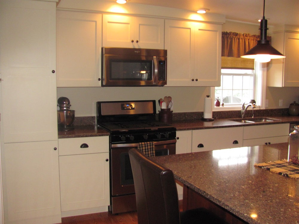 Modern kitchen with white cabinets and granite counters.