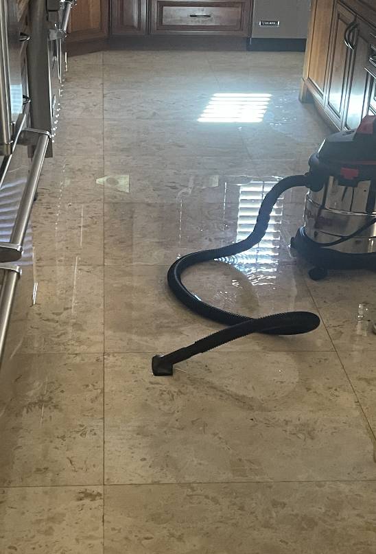 Emergency plumbing service needed to address a flooded kitchen floor.
