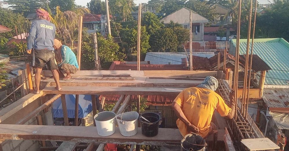 Skilled construction workers manage rebar and supplies on an elevated site