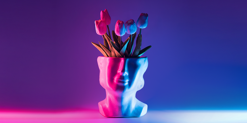 White planter that looks like a statue of a face with tulips coming out of the top