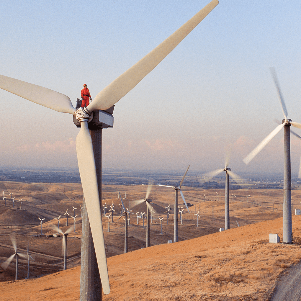A row of wind turbines on top of a hill