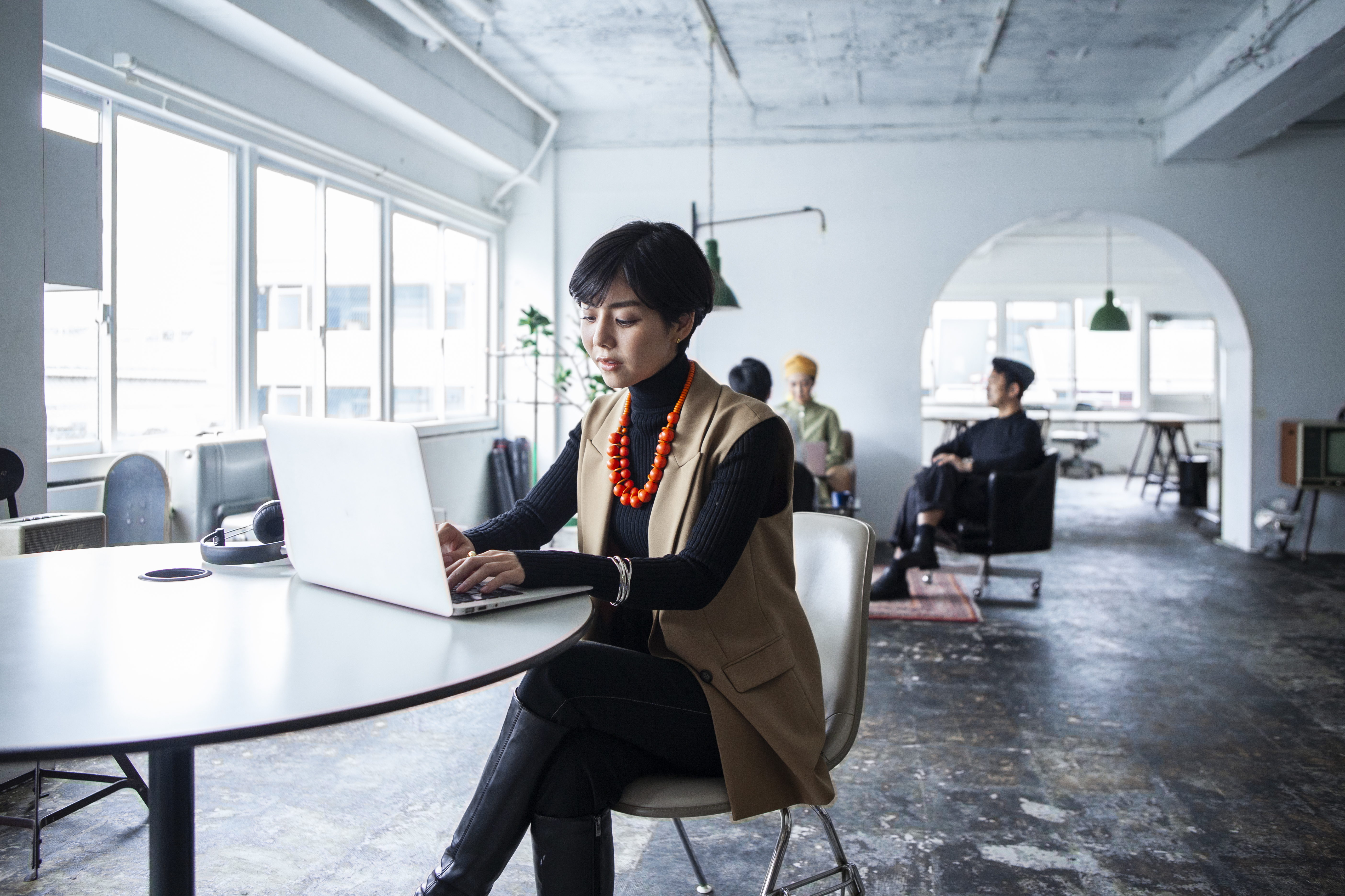 A businesswoman is sitting in a chair working on a laptop