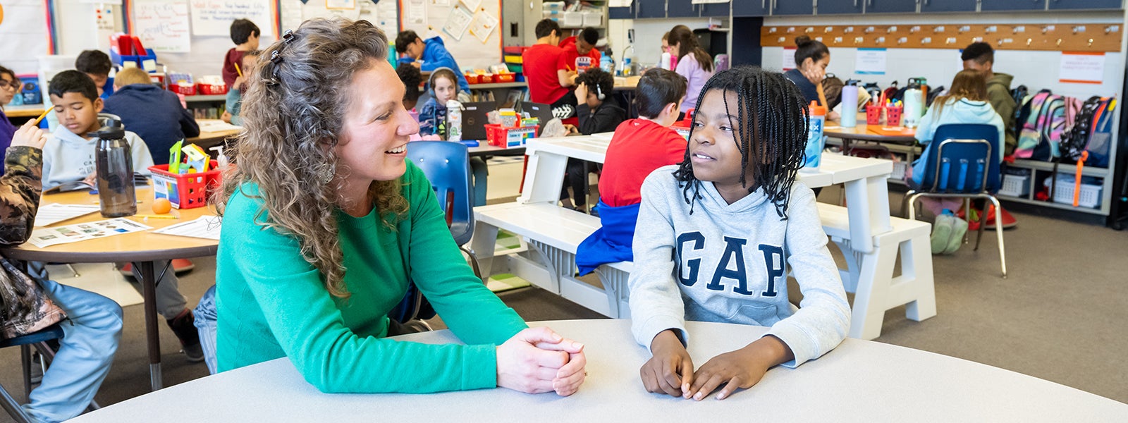 A teacher and student talk at a table