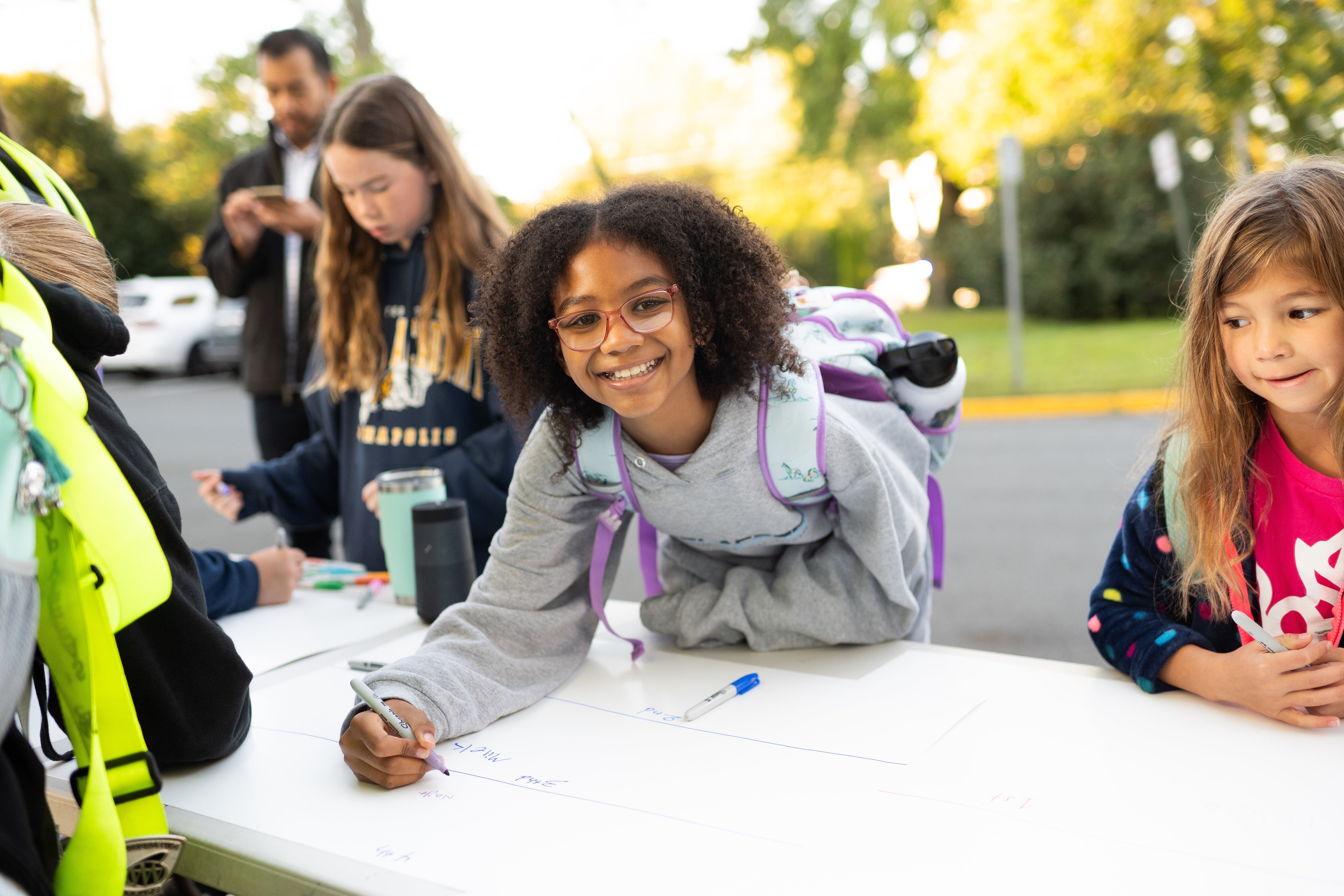 A student signs her name after walking to school, helping her class's chances to win the Golden Sneaker!