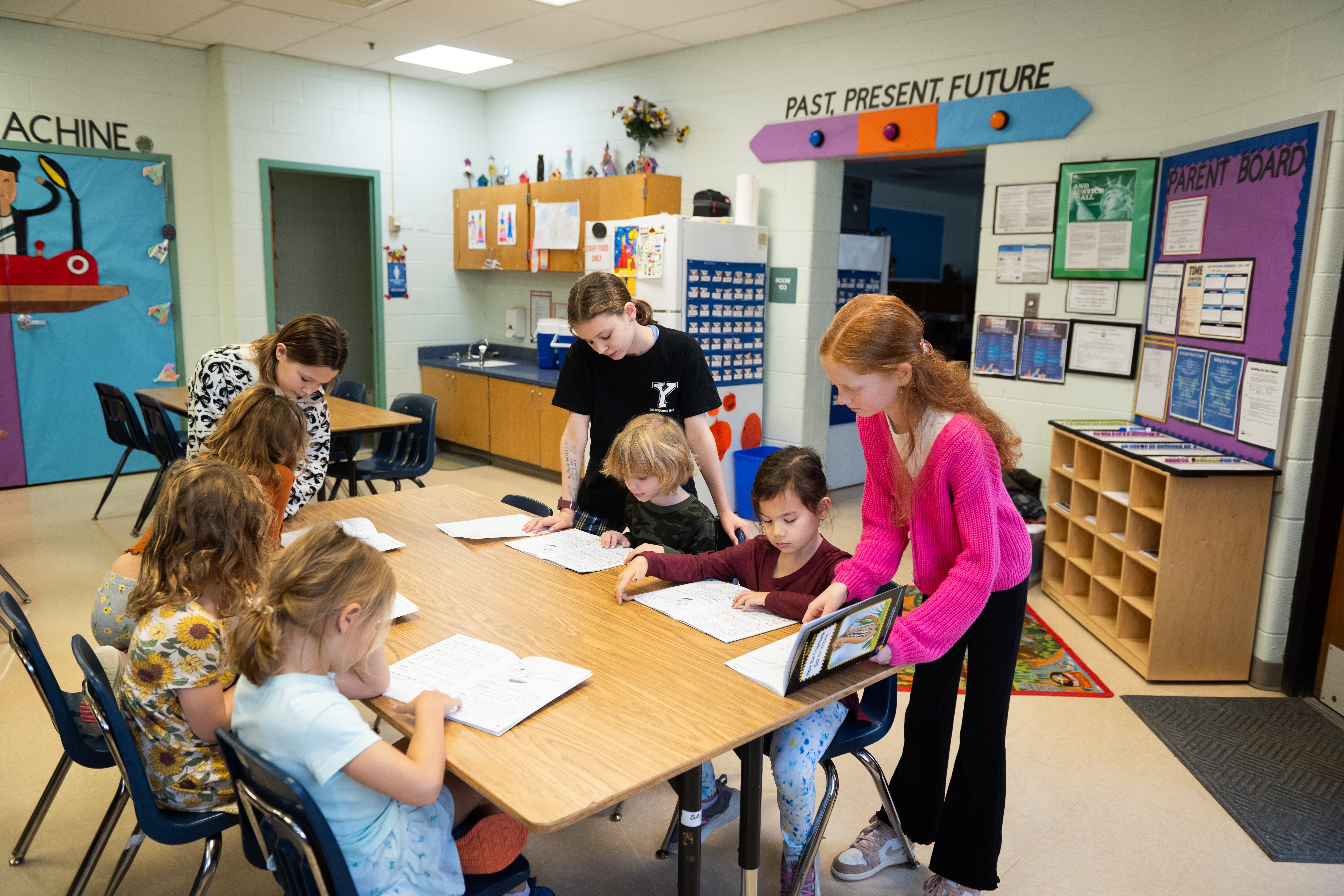 Students Ruth Gaffiney, Mae Ruth McGarrigal, and Caroline Andrews help first graders with a reading lesson.