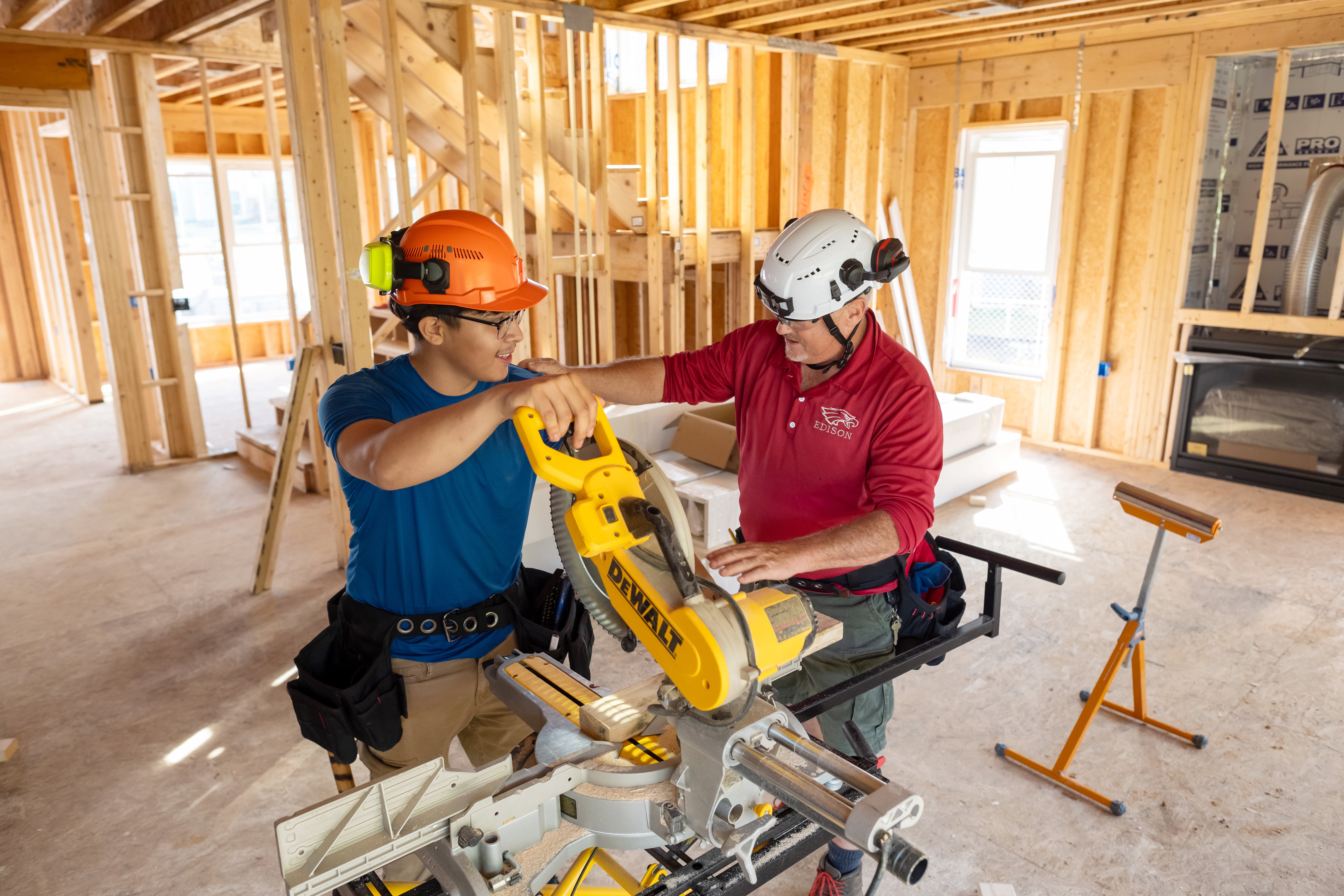 A student and instructor work at a table saw