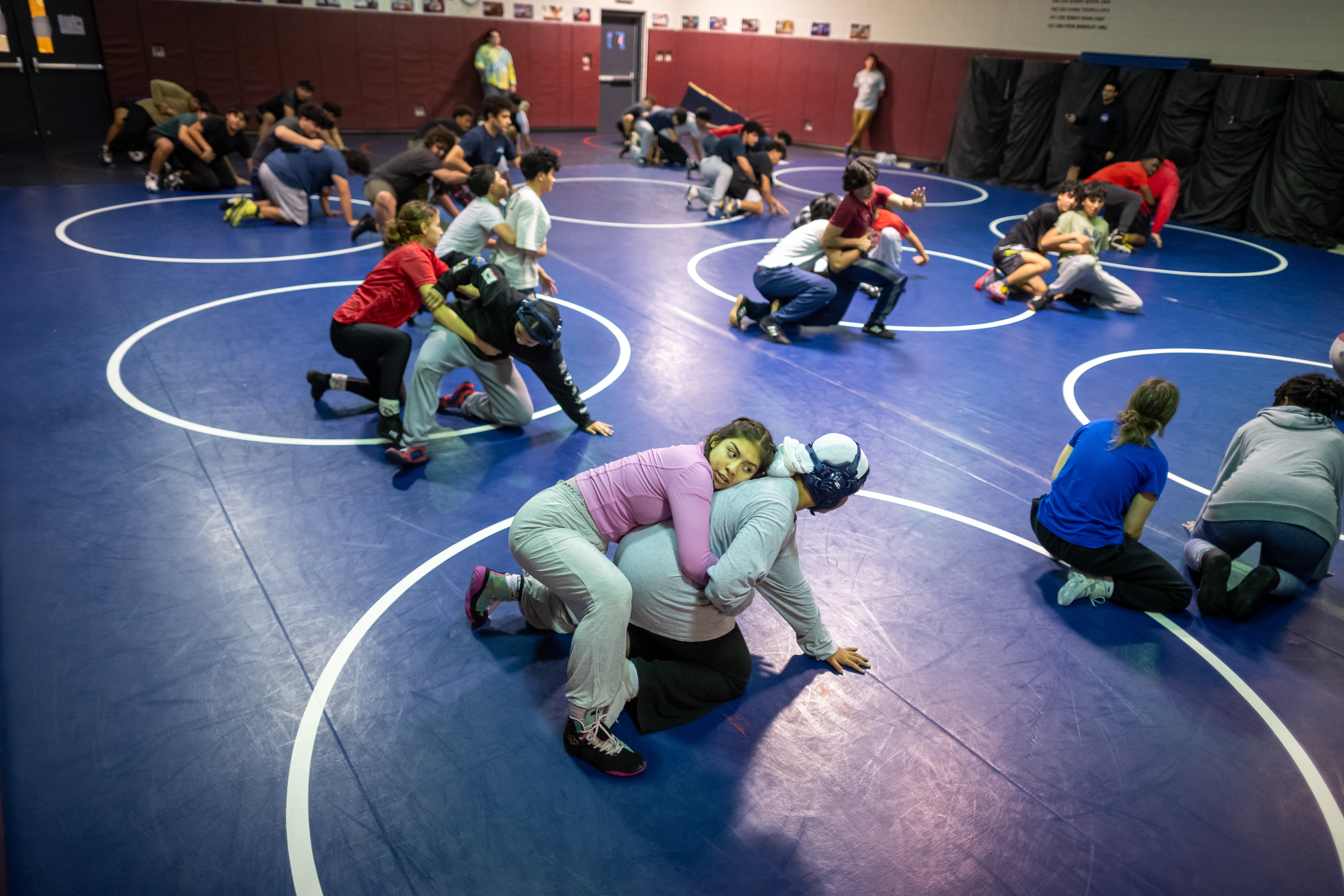 Dayana Meruvia, at center, grapples a partner in the Justice High School wrestling room.