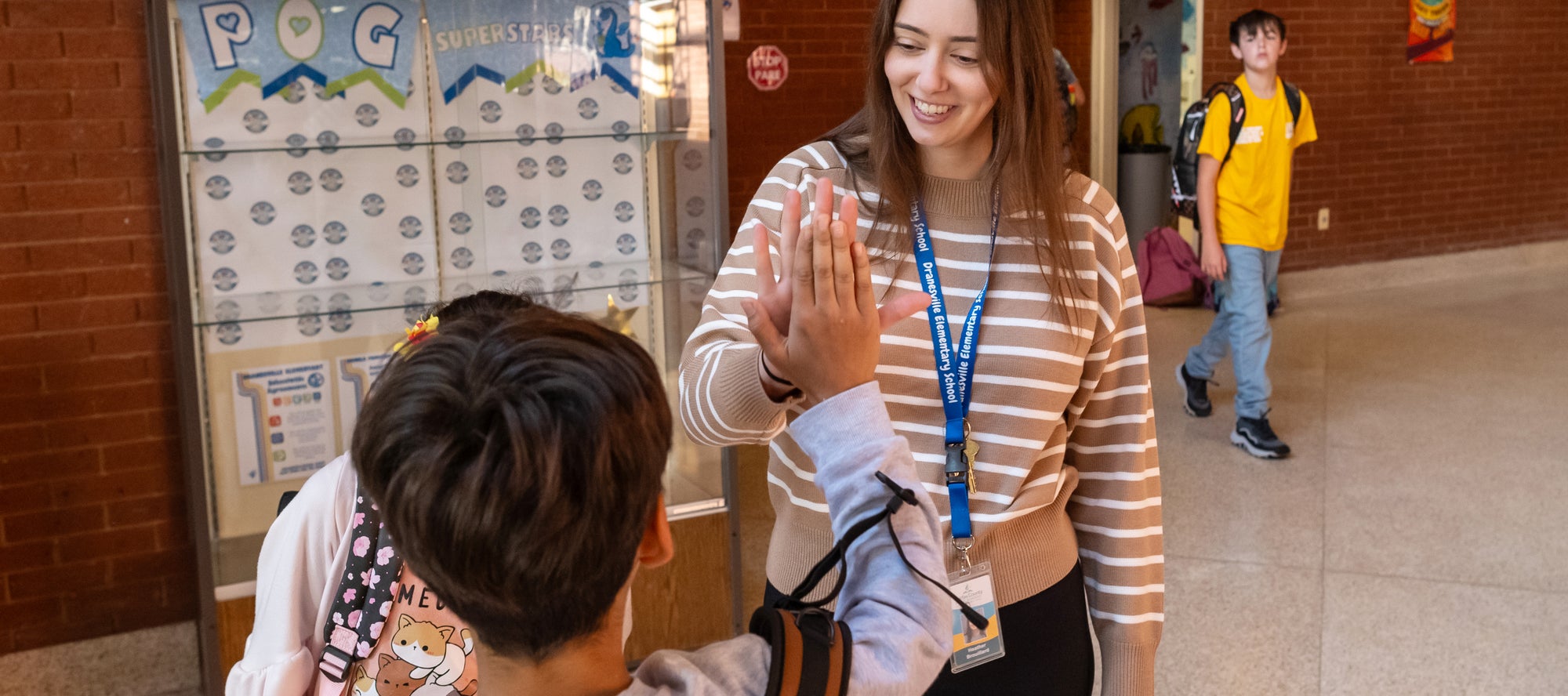Teacher giving a student a high five.