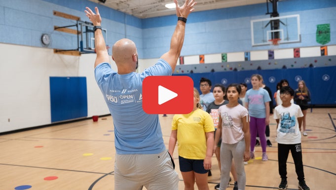 Basketball coach with students in gym