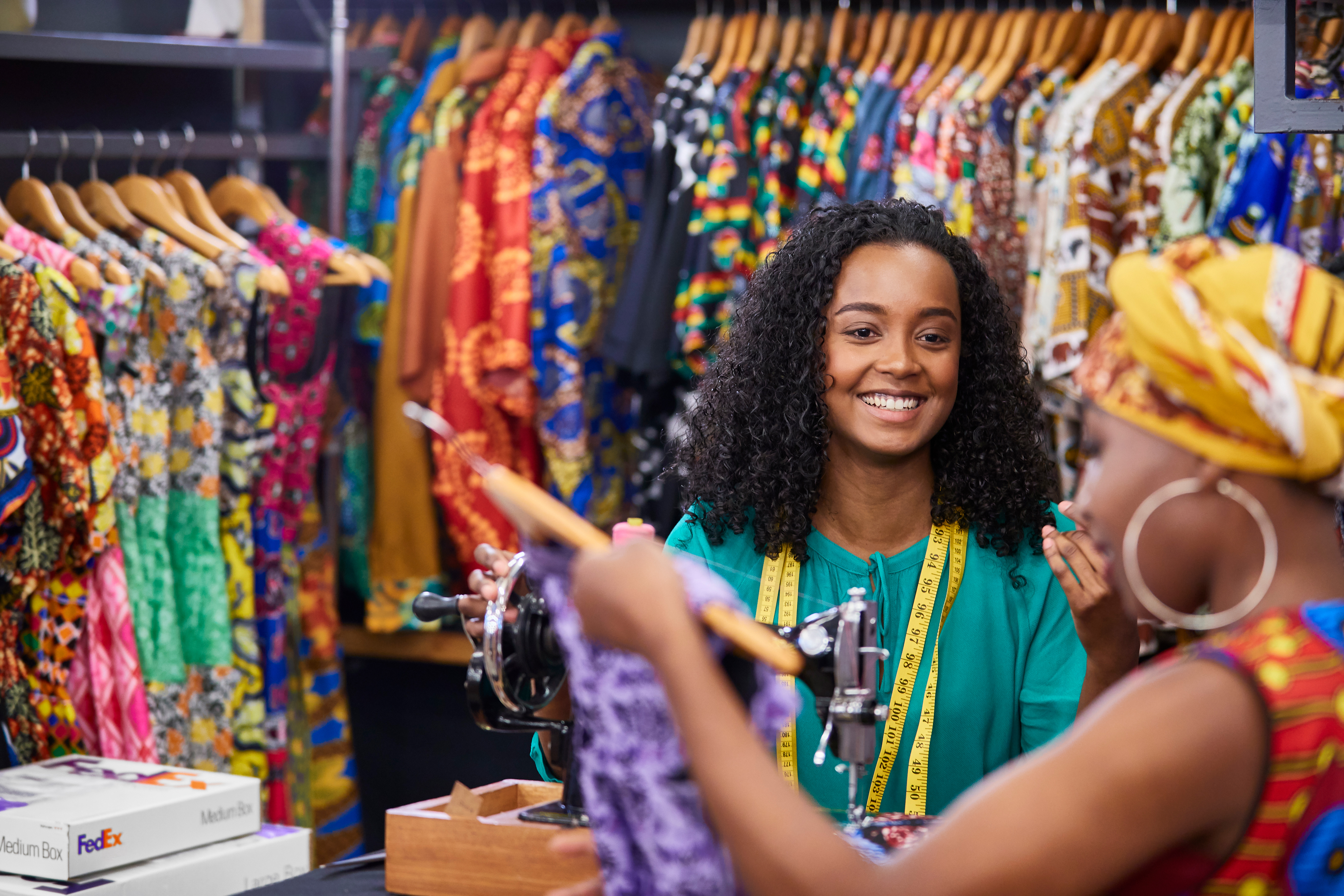 two smiling people looking at clothes with a couple of FedEx boxes nearby