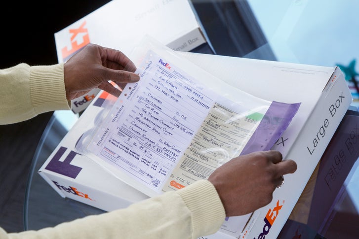 Person applying a FedEx® shipping label to a FedEx Express® box.