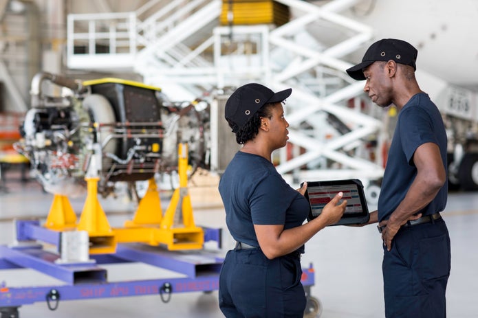 FedEx Employees looking talking while looking at a tablet