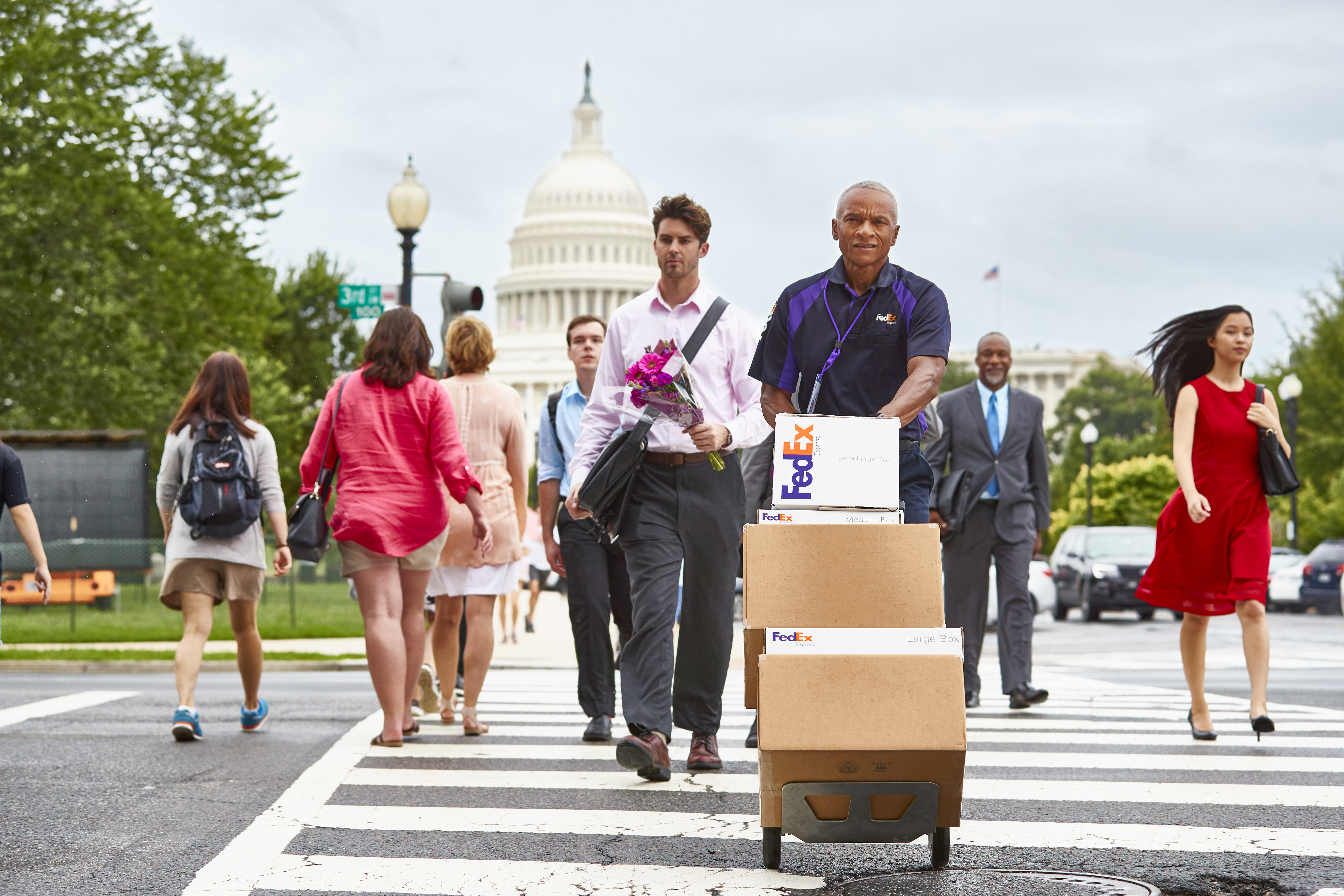 FedEx employee pusing packages in front of US Capitol