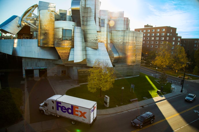 FedEx truck in city driving into receiving dock.