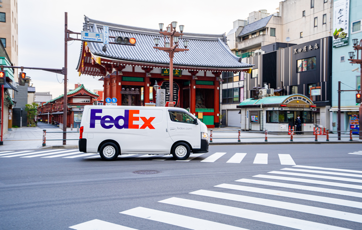 A FedEx van driving down a street