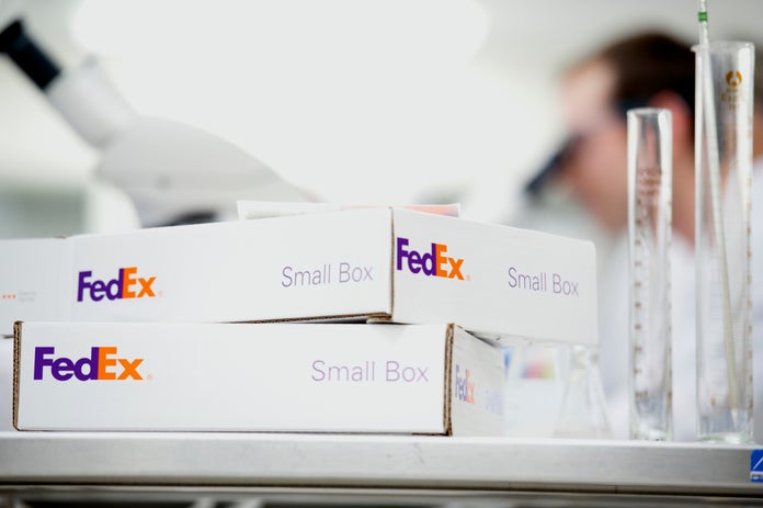 FedEx Small Boxes on counter with beakers and a microscope