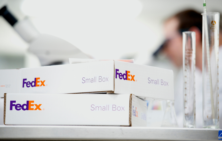 A stack of white shipping boxes on a lab table