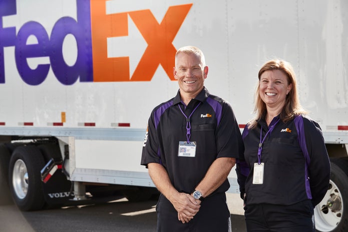FedEx Ground employees get ready to make a delivery.