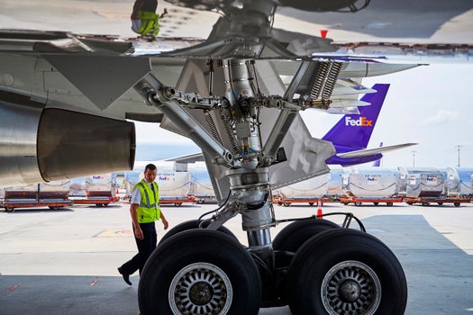 Addetto FedEx che cammina sotto un aereo in un hub FedEx