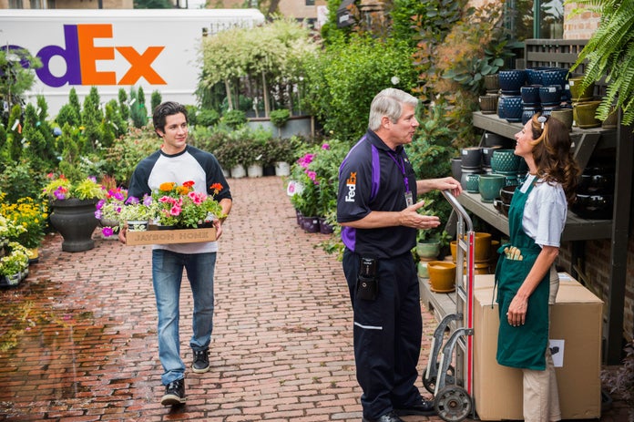 Corriere FedEx che consegna un collo presso una serra