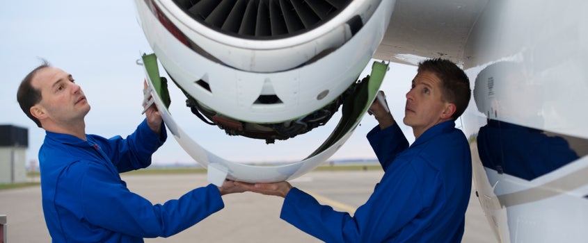 deux employés travaillant sur un moteur d’avion