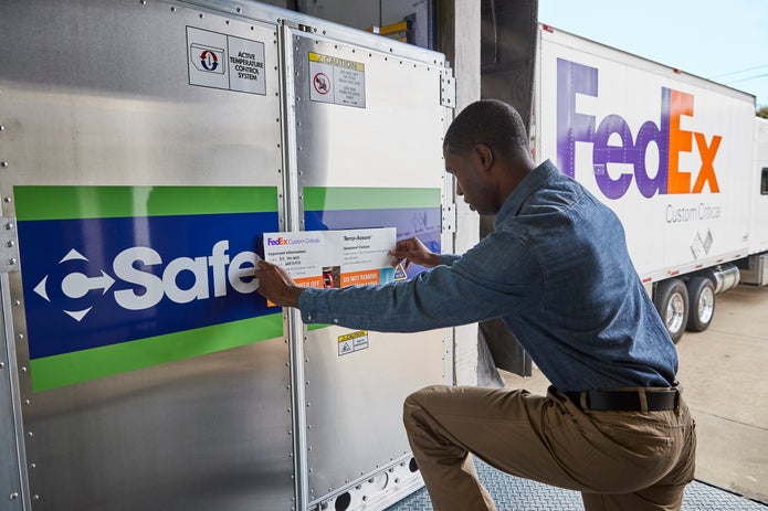 Man applies FedEx label to FedEx Custom Critical shipment