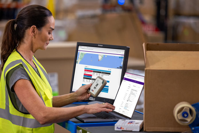 Person looking at package and entering info into a computer