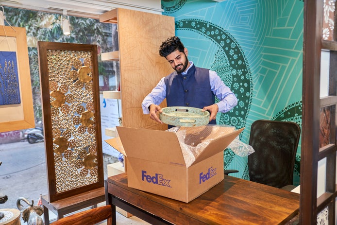 Personne plaçant un bol dans un carton FedEx
