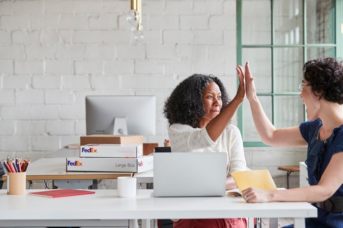 Two women giving each other a high five
