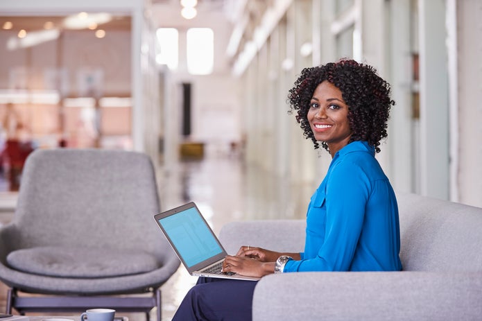 Woman working on a laptop and smiling