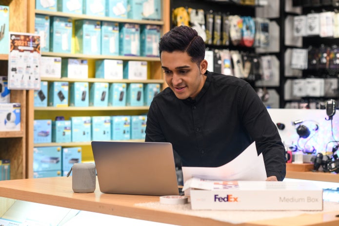Man looking at shipment orders on laptop