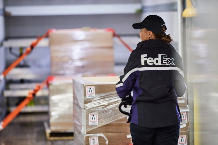 A FedEx courier delivers a Custom Critical package