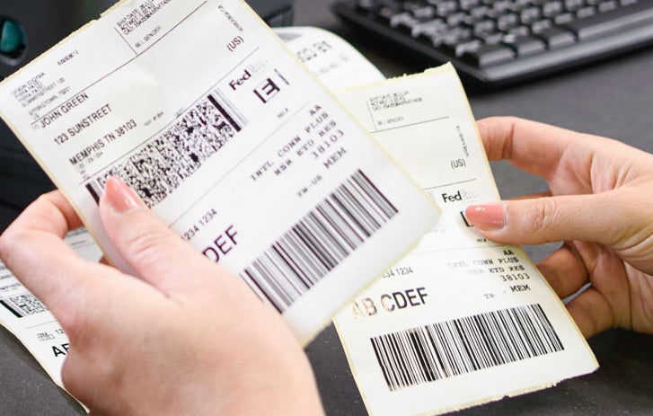 person holding FedEx labels