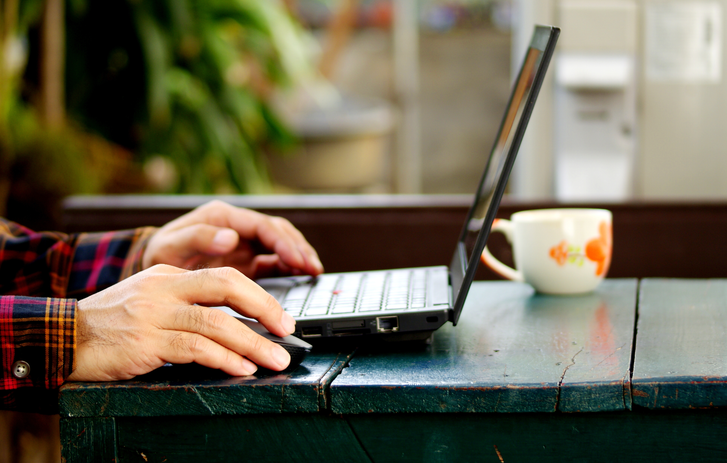 Hands typing on a laptop