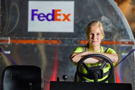 FedEx Employee driving a cart with packages in tow