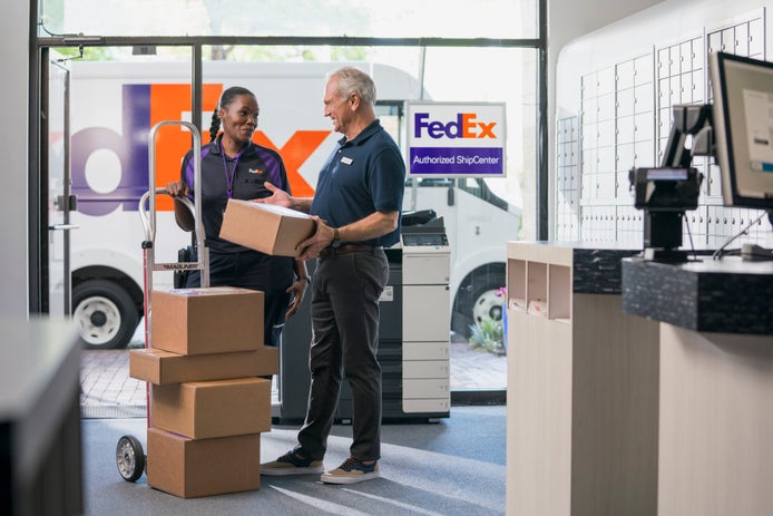 FedEx courier delivering packages to FedEx Authorized ShipCenter.